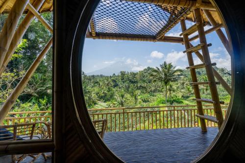 a view from the inside of a hammock on a balcony at Velonia Iseh in Sidemen