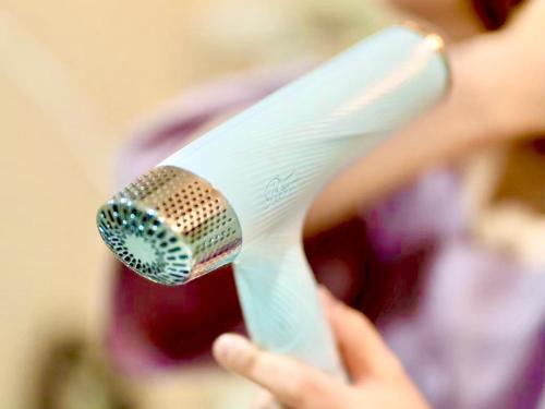a person holding a microphone in their hand at HOTEL minimumms女性専用カプセルホテルWomen only hotel in Naha