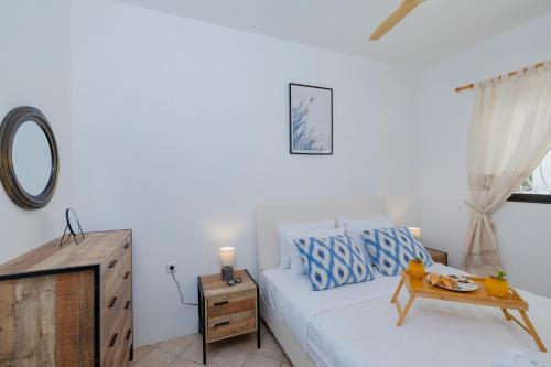 a white bedroom with a bed and a table at Eco Beach And Magic Garden Hotel in Gennadi