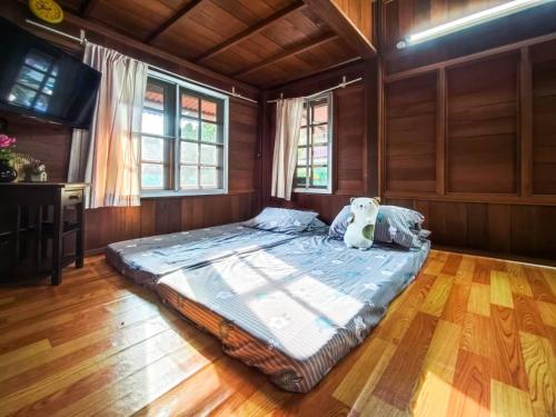 a large bed in a room with wooden floors and windows at Sekinchan 231 VA Chalet in Sekincan
