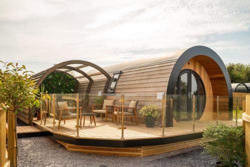 a house with a deck with a table and chairs at Eira Pod - Luxury Glamping escape - private Hot tub in Pembroke