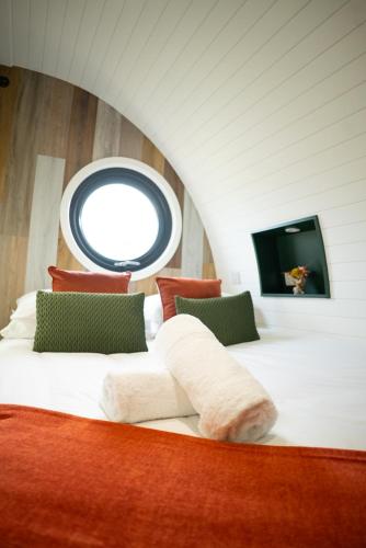 a bedroom with a large white bed with a window at Eira Pod - Luxury Glamping escape - private Hot tub in Pembroke