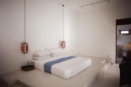 a white bed in a white room with two lamps at Villa Aditi - Amazing Beachfront Villa in Amphoe Koh Samui