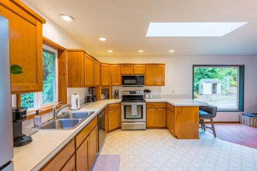 a kitchen with a sink and a stove top oven at Fern House Rustic Modern Hiking Base Sequim in Sequim