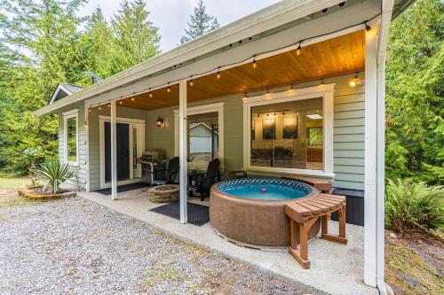 a house with a hot tub on a patio at Fern House Rustic Modern Hiking Base Sequim in Sequim
