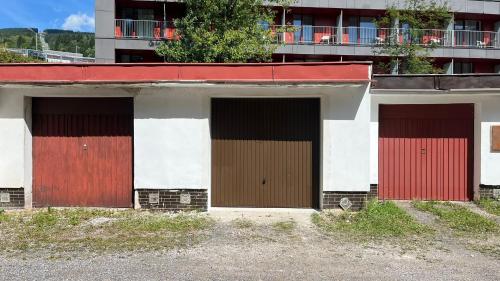 a group of four garage doors on a building at Stylový apartmán přímo u lanovky, vlastní garážové stání in Janske Lazne