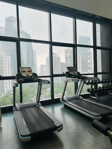 two exercise machines in a room with a large window at KL suites by Nomad in Kuala Lumpur