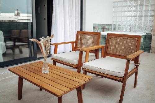 three chairs and a table with a vase on a table at Hotel Alba Seleqtta in Lloret de Mar
