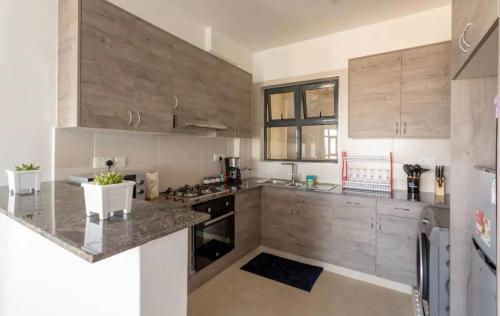 a kitchen with marble counter tops and wooden cabinets at Skyline Aramis Apartment Westlands,2bedroom,2baths in Nairobi