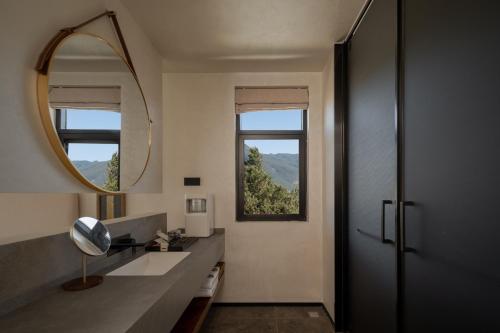 a bathroom with a large mirror and a sink at 不晚里予日照金山丨雪山全景度假酒店白沙古镇店 in Baisha