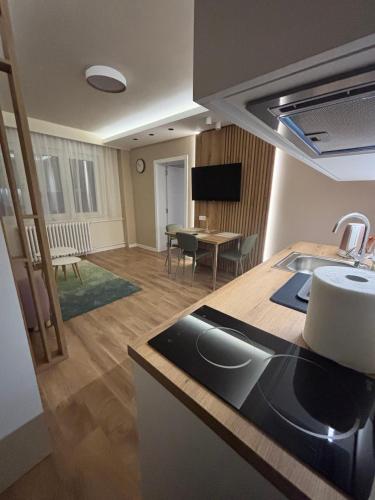 a kitchen and a living room with a table at Hello One 2 Apartman in Šabac