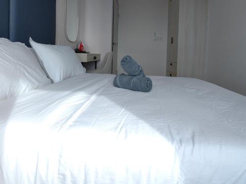 a stuffed animal sitting on top of a bed at Vetro11 Beside QEH1 by JUNE Homestay in Kota Kinabalu