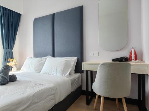 a bedroom with a bed and a desk and a chair at Vetro11 Beside QEH1 by JUNE Homestay in Kota Kinabalu