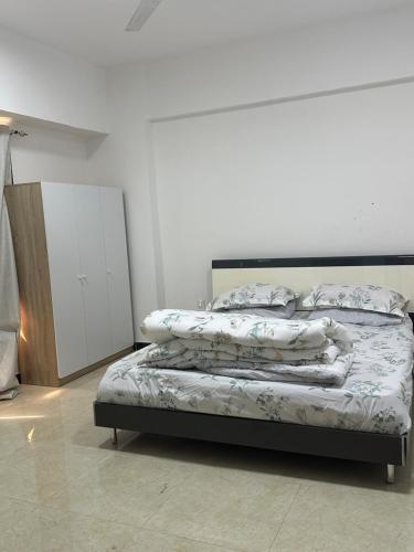 a bedroom with a bed with pillows on it at Ghala apartment Near airport free Wifi in Muscat