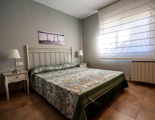 a bedroom with a bed and a table and a window at Les Columnes in Vespella de Gaià 