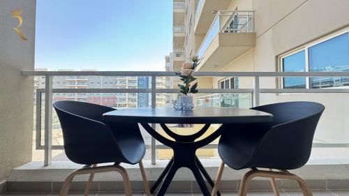 a table and two chairs in front of a balcony at King Bed Studio - Chic Cozy Retreat in Abu Dhabi