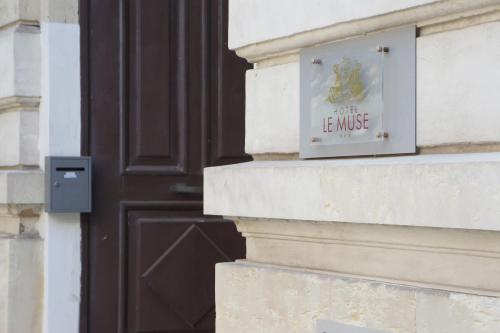 a sign on a building in front of a door at Hotel le Muse in Siracusa