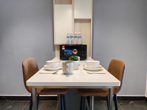 a white table with chairs and a microwave at Vetro11 Beside QEH1 by JUNE Homestay in Kota Kinabalu