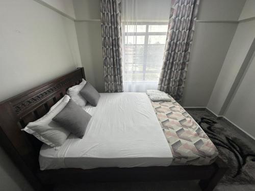 a bedroom with a large bed with a window at Ecostay Economy 2bed424 in Kisumu