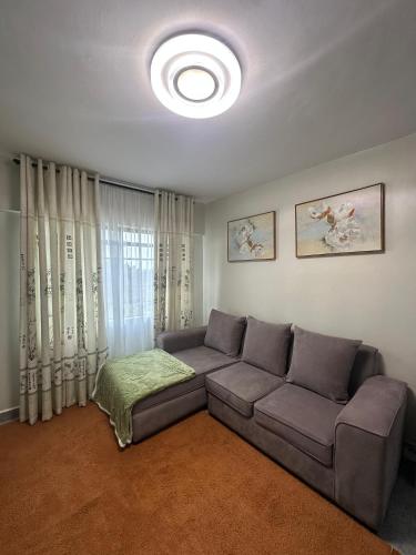 a living room with a couch and a window at Ecostay Economy 2bed424 in Kisumu