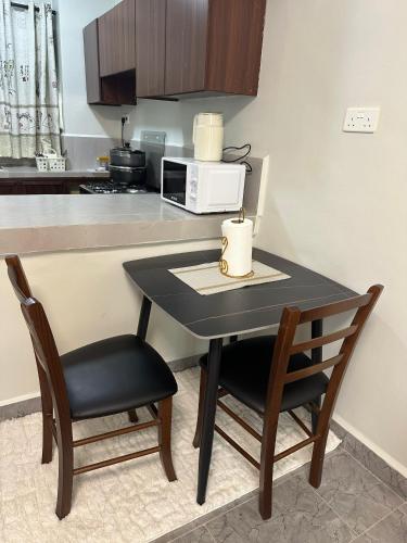 a kitchen with a table and two chairs and a microwave at Ecostay Economy 2bed424 in Kisumu