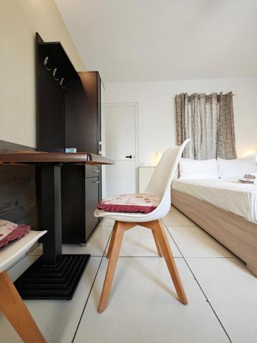 a white chair in a bedroom with a bed and a desk at Corner view 4 in Marsaskala