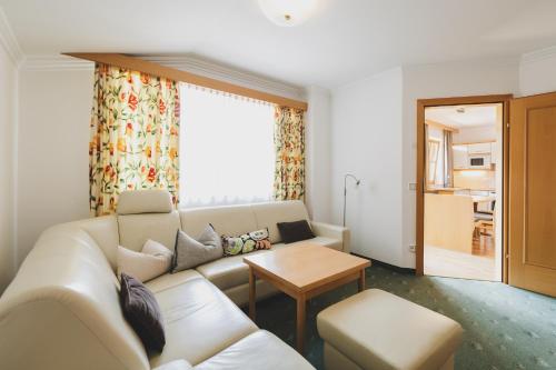 a living room with a couch and a table at Das Jennerwein Appartement in Saalbach Hinterglemm