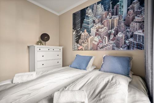 ein Schlafzimmer mit einem Bett und einem Gemälde an der Wand in der Unterkunft Bergen Beds Apartments - A Front Row Experience in Bergen