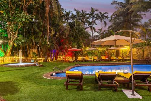 a pool with tables and chairs and an umbrella at 3 BHK Apartment with swimming pool in Jāmb