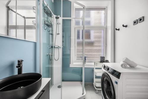 ein Badezimmer mit Waschbecken und Waschmaschine in der Unterkunft Bergen Beds Apartments - A Front Row Experience in Bergen