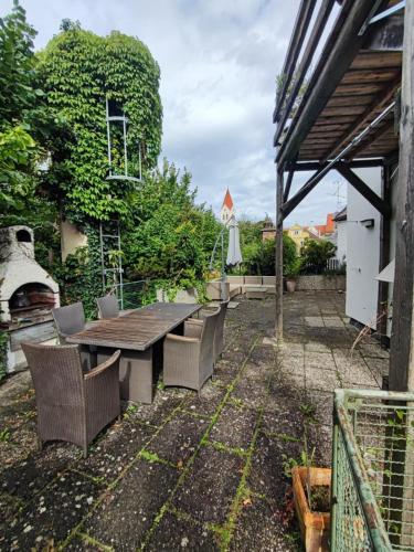a patio with a table and chairs in a yard at Altbau-Traum mit Riesen-Dachterrasse in Moosburg