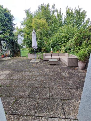 a patio with an umbrella and a couch and an umbrella at Altbau-Traum mit Riesen-Dachterrasse in Moosburg