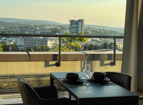 プフォルツハイムにあるZentrale Penthouse Suiten mit Goldstadtblickの市街の景色を望むテーブルと椅子