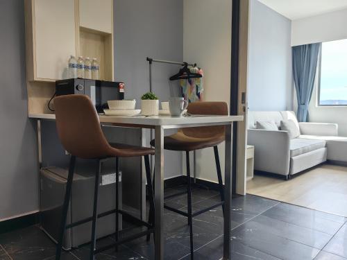 a kitchen and living room with a table and chairs at Vetro11 Beside QEH1 by JUNE Homestay in Kota Kinabalu