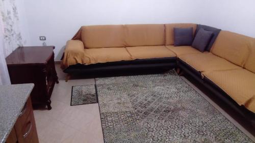 a brown couch in a living room with a table at Kukesi Center Apartments in Kukës