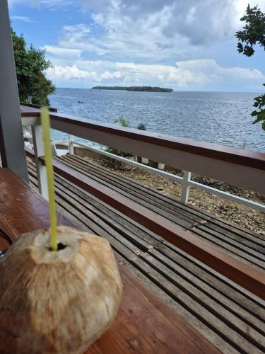a strawhat sitting on a bench next to the ocean at Tulang Diot View Resort and Turtle Haven in Camotes Islands