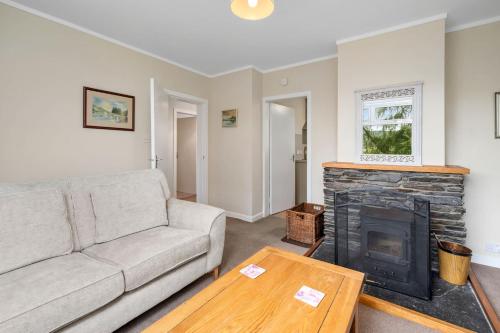 a living room with a couch and a fireplace at Charming 2-Bed Cottage on Tranquil Raera Farm in Kilninver