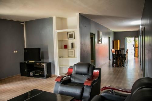 a living room with two chairs and a television at Villa Saint Michel in Lomé