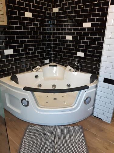 a bath tub in a bathroom with a black wall at Le marché couvert in Étretat