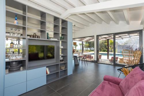 a living room with a purple couch and a tv at Villa White Oleander Etna and Pool in Calatabiano