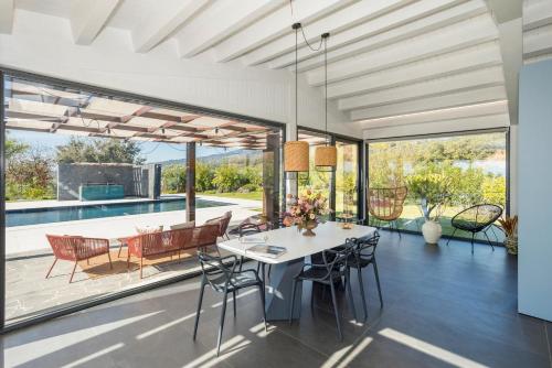 a dining room with a table and chairs and a patio at Villa White Oleander Etna and Pool in Calatabiano