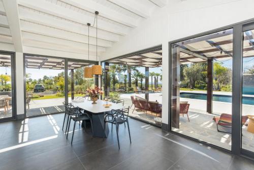 a dining room with glass doors and a table with chairs at Villa White Oleander Etna and Pool in Calatabiano