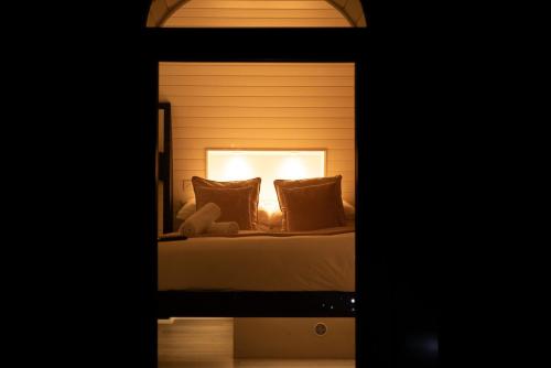 a bedroom with a bed with a light on it at Luxury Glamping Tali Pod Escape with Private HotTub in Pembroke