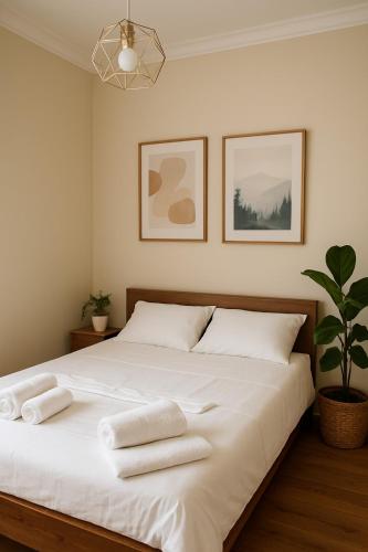 Un dormitorio con una gran cama blanca con toallas. en Chill House, en Kutaisi