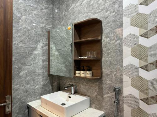 ein Badezimmer mit Waschbecken und Spiegel in der Unterkunft Bliss Homestay Huế in Thôn Lại Thê