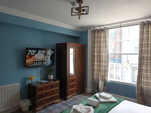 a bedroom with a bed and a dresser and a window at The City Hotel in Durham