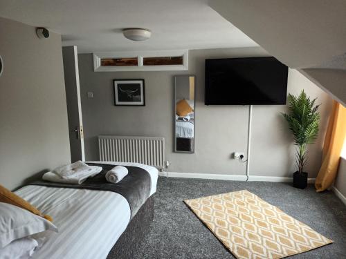 a bedroom with a bed and a flat screen tv at The City Hotel in Durham