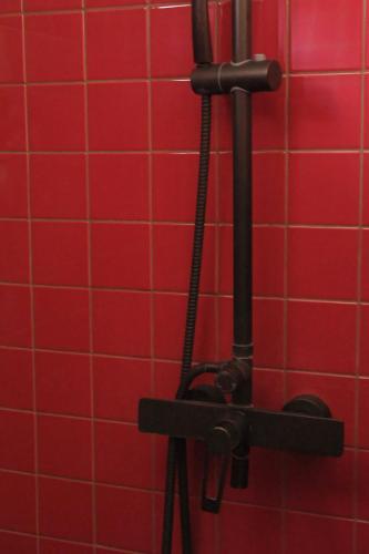a red tiled wall in a bathroom with red tiles at Frank86 in Băile Tuşnad