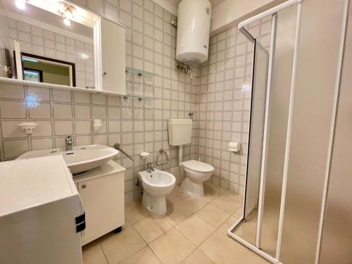 ein Badezimmer mit Toilette, Waschbecken und Dusche in der Unterkunft A few steps from the beach in Porto Santa Margherita