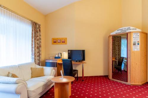 a living room with a couch and a table at Königshof Hotel Resort in Oberstaufen